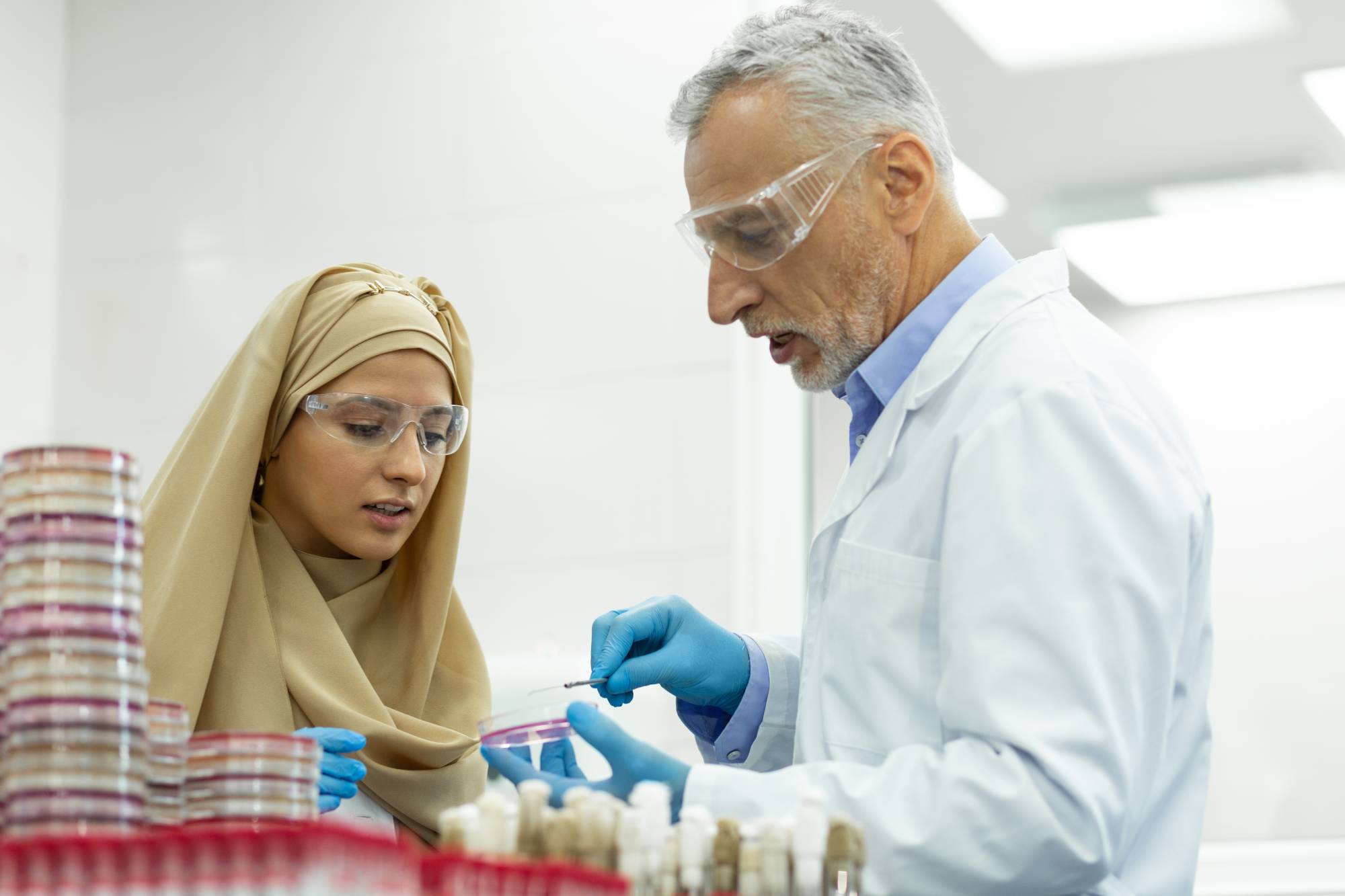 Attentive international student helping her mature doctor